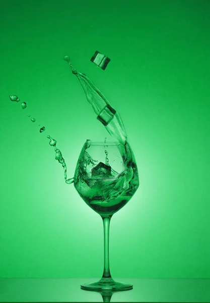 Cubetti Ghiaccio Cadono Bicchiere Acqua Versata Acqua Spruzzata Bicchiere Vino — Foto Stock