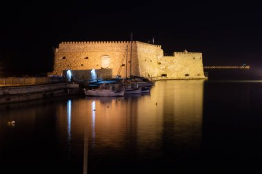 Geceleri Venedik Koules Kalesi ile Heraklion 'un eski limanının manzarası. Girit, Yunanistan. Geceleri Heraklion. Iraklion 'daki Koule Kalesi, gece.. 