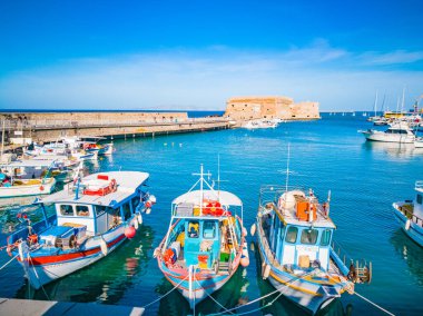 Heraklion, Girit 'ten limana güzel bir manzara. Heraklion Koule, kale. Heraklion şehrinin limanında mavi gökyüzü ve turkuaz deniz. Yunan limanında renkli tekneler. Seyahat ve yerler.