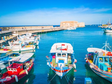 Heraklion, Girit 'ten limana güzel bir manzara. Heraklion Koule, kale. Heraklion şehrinin limanında mavi gökyüzü ve turkuaz deniz. Yunan limanında renkli tekneler. Seyahat ve yerler.