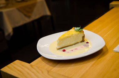 Düz New York Cheesecake bir dilim beyaz plaka üzerinde