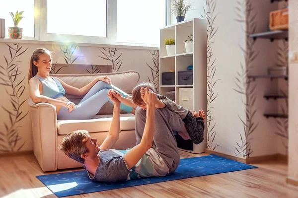 A sports family is engaged in fitness and yoga with a baby at home. Stay home in quarantine.