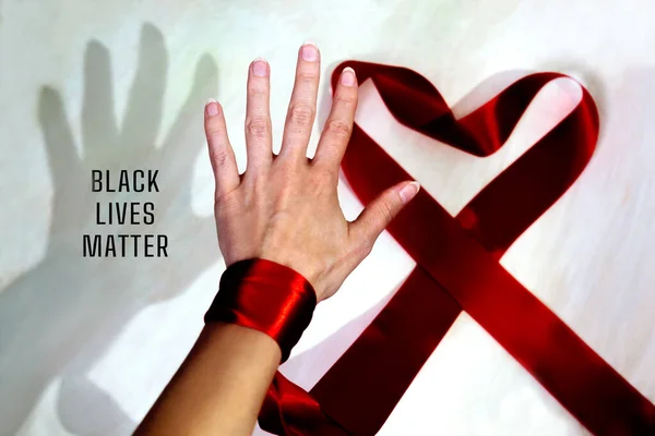 Black shadow and white palm and inscription Black Lives Matter. Heart from red ribbon. Equal Symbol. No racism concept.