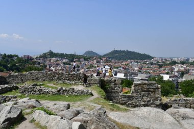 Plovdiv, Bulgaristan - 08 Haziran 2018: Nebet tepesindeki antik kaleyi gezerek kimliği belirsiz turistler, farklı binalara, dzhumaya camisine ve saat kulesine şehir manzaralı