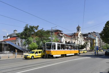 Sofia, Bulgaristan - 16 Haziran 2018: Kimliği belirsiz kişi ve genel tramvay ve arabalar, Merkez Pazar bina ve arkasında Yahudi sinagog ile trafik