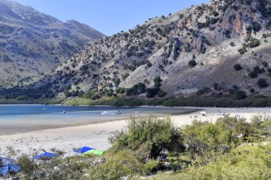 Georgioupolis, Yunanistan - 06 Ekim 2018: Kimliği belirsiz kişiler Kournas Gölü, yüzme ve botla için tercih edilen seyahat hedef