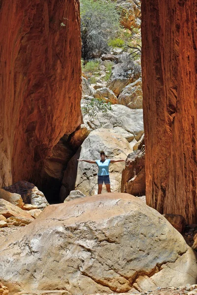 Australia, NT, woman between rock face of stunning Standley Chasm in McDonnell national park near Alicve Springs