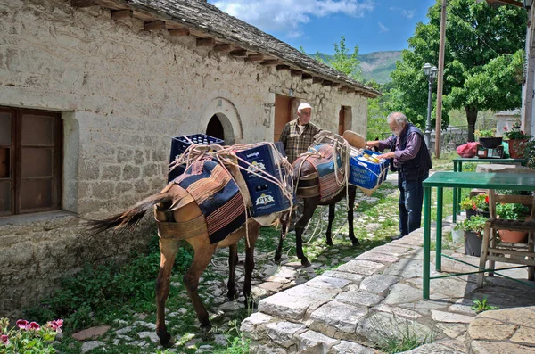 Kalarites, Yunanistan - Haziran 06, 2019: Tzoumerka Ulusal Parkı 'ndaki bir Aromanian köyü olan Kalarites dağ köyünde kimliği belirsiz adamlar, geleneksel ulaşım için kullanılan eşekler, çünkü trafik ve caddeler mümkün değil.
