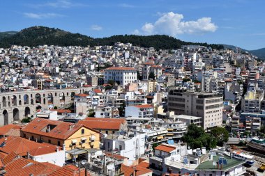 Kavala, Yunanistan - 13 Haziran 2019: Ortaçağ su kemeri ve Ege Denizi üzerindeki kentteki binalar