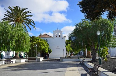 Yaiza, İspanya - 16 Ocak 2012: Lanzarote, Kanarya Adası 'ndaki küçük bir köyde Nuestra de los Remedios kilisesi ile ana meydanda kimliği belirsiz insanlar - Plaza de los Remedios -