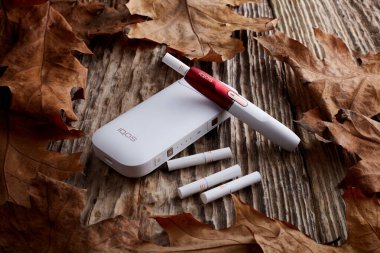 Ekim 19.2019, Hamm, Almanya: Philip Morris şirketinin yeni nesil elektronik sigarası, eski ahşap arka planda.