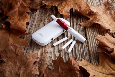 Ekim 19.2019, Hamm, Almanya: Philip Morris şirketinin yeni nesil elektronik sigarası, eski ahşap arka planda.