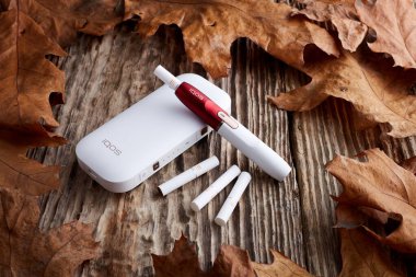 Ekim 19.2019, Hamm, Almanya: Philip Morris şirketinin yeni nesil elektronik sigarası, eski ahşap arka planda.