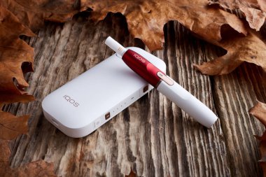 Ekim 19.2019, Hamm, Almanya: Philip Morris şirketinin yeni nesil elektronik sigarası, eski ahşap arka planda.