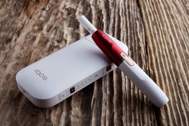 Ekim 19.2019, Hamm, Almanya: Philip Morris şirketinin yeni nesil elektronik sigarası, eski ahşap arka planda.