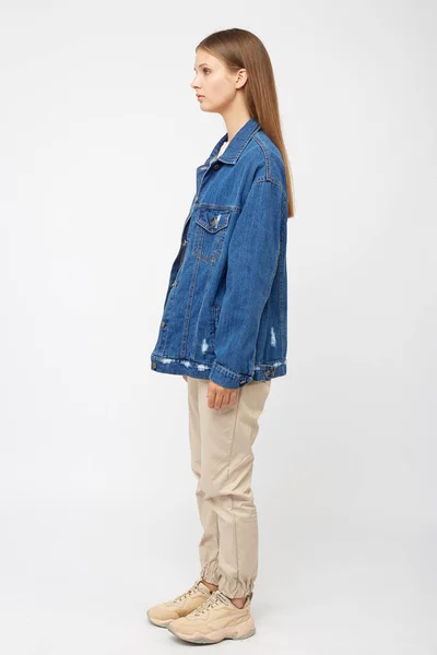 Meisje in beige cargo broek en een denim jas. — Stockfoto