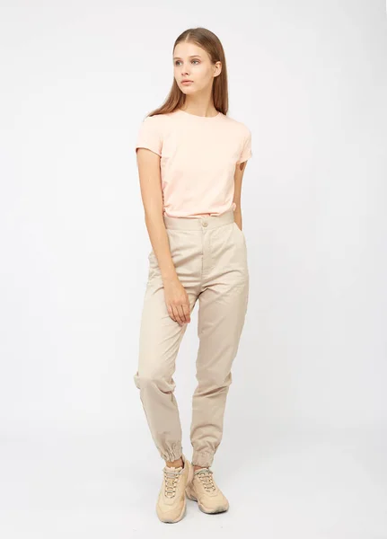 Flicka i beige last byxor och en t-shirt — Stockfoto