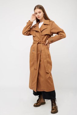 Beyaz arka planda dişi yağmurluk deve rengi izole edildi.