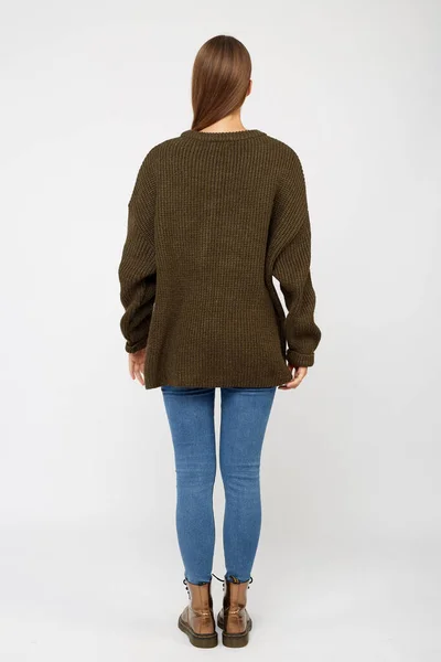 Flicka klädd i en khaki tröja och jeans. — Stockfoto