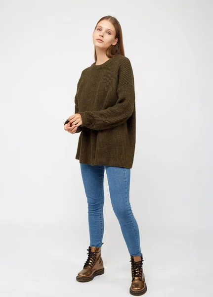 Девушка в свитере цвета хаки и джинсах . — стоковое фото