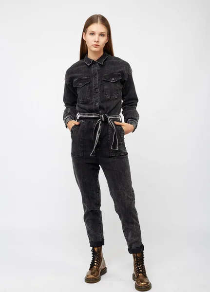 Flicka i svart denim overall på vit bakgrund. — Stockfoto