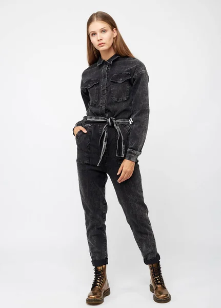 Meisje in zwart denim jumpsuit op witte achtergrond. — Stockfoto