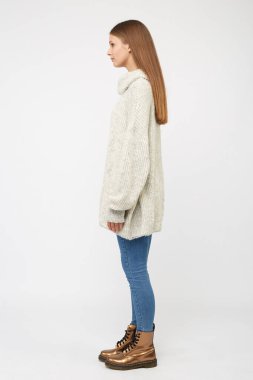 Beyaz kazak ve kot giyen bir kız..