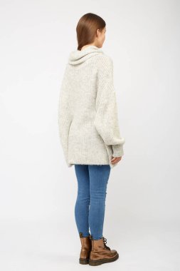 Beyaz kazak ve kot giyen bir kız..