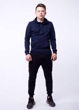 Siyah kapüşonlu, elleri ceplerinde duran yakışıklı ve ciddi bir gencin izole edilmiş portresi. Hackleme ve moda kavramı