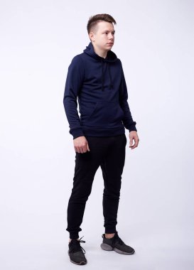 Siyah kapüşonlu, elleri ceplerinde duran yakışıklı ve ciddi bir gencin izole edilmiş portresi. Hackleme ve moda kavramı