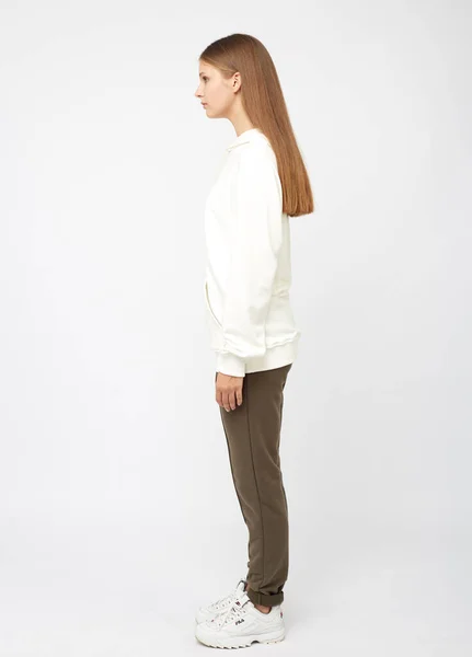 グレーのスポーツウェアのスウェットシャツのパーカーを身に着けている若い女性の肖像画、白い背景に孤立したスタジオイメージ — ストック写真