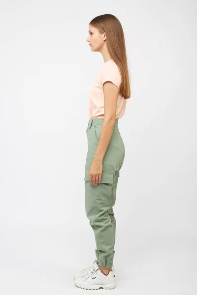 Yeşil pantolonlu ve tişörtlü bir kız. — Stok fotoğraf