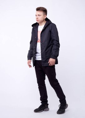 genç yakışıklı duran mavi bir ceket giyen adam. Beyaz arka plan.