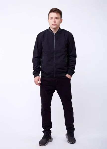 Jovem de jeans, jaqueta de bombardeiro preto no fundo branco . — Fotografia de Stock