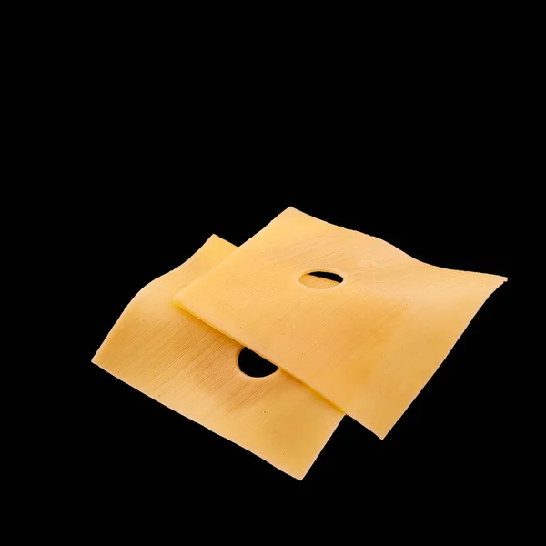 Павлины желтого сыра на чёрном фоне — стоковое фото