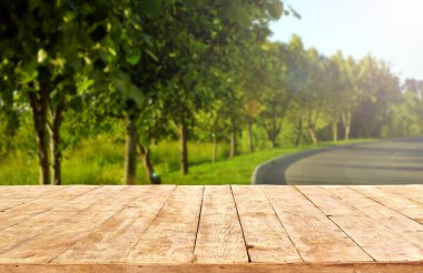 Modelleme. Yaprak bokeh arkaplanlı boş ahşap güverte masası.