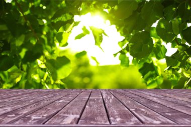 Modelleme. Yaprak bokeh arkaplanlı boş ahşap güverte masası.