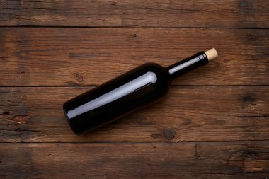 Ahşap masa arkasında kırmızı şarap şişesi. Kopyalama alanı olan üst görünüm. Model.