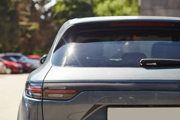 Back window of a car parked on the street in summer sunny day, rear view. Mock-up for sticker or decals