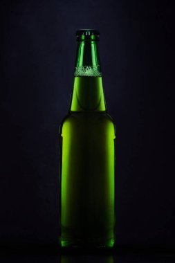 Siyah arka planda yeşil bira şişesi