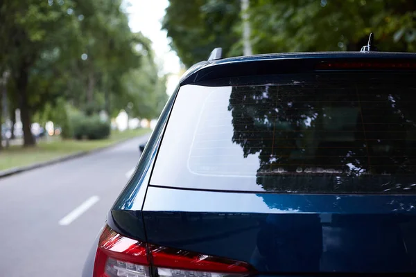 Rückscheibe eines blauen Autos, das an einem sonnigen Sommertag auf der Straße geparkt war, Rückansicht. Mock-up für Aufkleber oder Abziehbilder — Stockfoto