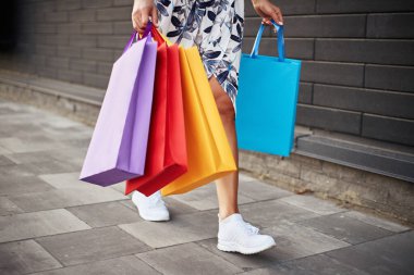 Kara Cuma. Elinde kağıt torbalar tutan bir kadın. Alışveriş merkezi.