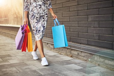 Kara Cuma. Elinde kağıt torbalar tutan bir kadın. Alışveriş merkezi.