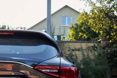 Yazın güneşli bir günde, arka pencereye park etmiş gri bir araba. Çıkartma veya çıkartma için modelleme