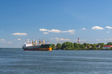 Kargo gemisi kıyıya yakın boğazdan geçiyor.