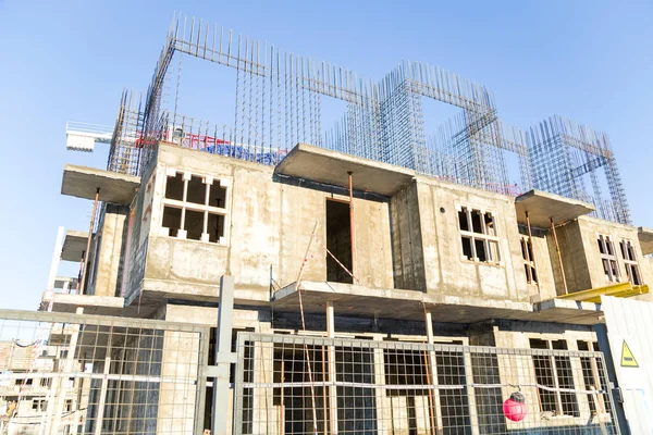 Mavi gökyüzüne karşı bir çitin arkasında inşaat şantiye