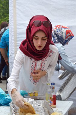 Bükreş, Romanya. 22 Mayıs. Güzel genç Türk kadını Bükreş'teki Türk Festivali'nde geleneksel suberek turtaları servis ediyor.