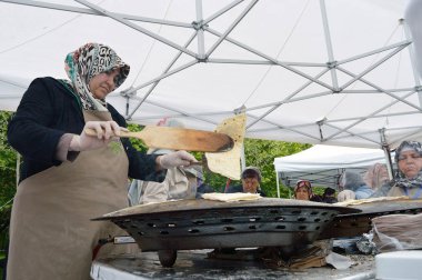 Bükreş, Romanya. 22 Mayıs 2016. Bükreş'teki Türk Festivali'nde Türk kadını saj fırınına türk ekmeğini çevirdi. 