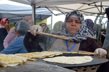 Bükreş, Romanya. 22 Mayıs 2016. Bükreş'teki Türk Festivali'nde üst düzey Türk kadını tarafından yakından denetlenen saj fırınında pişirilmiş yassı ekmek.