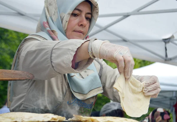 ブカレスト ルーマニア2016年5月22日トルコの女性は ブカレストのトルコフェスティバルで Sajオーブンで伝統的な平らなパンのベーキングプロセスを超えています — ストック写真